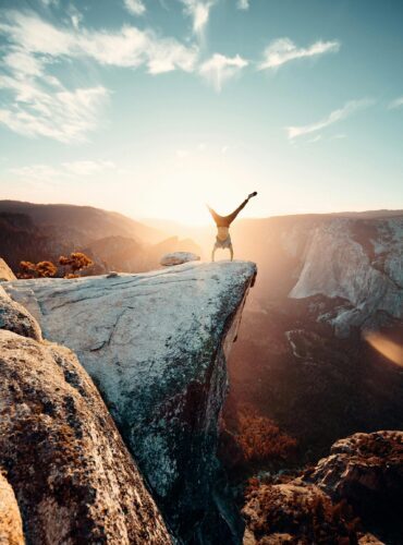 Thrilling handstand on a cliff edge in Yosemite National Park during sunset.